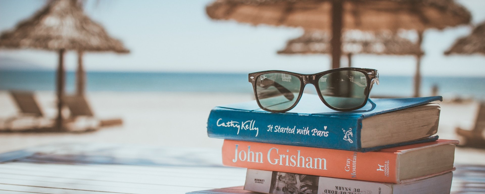 a pile of books on a table at the beach