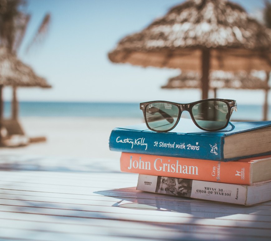 a pile of books on a table at the beach